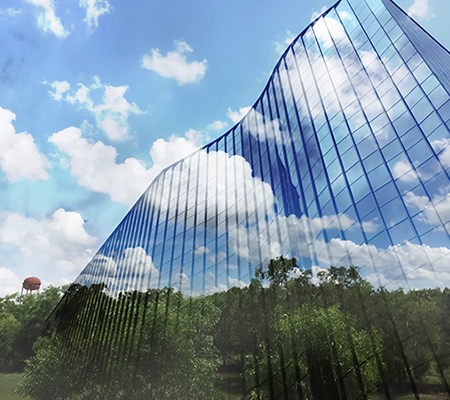 Sustainability - blue skies with green trees by a building